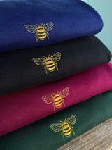 Embroidered golden bumble bee shown on some of the available colours. Stack of navy, black, burgundy and forest green.
