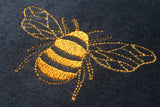 Close up of embroidered bumble bee, glitter thread.