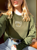 Monaco embroidered design onto forest green sweatshirt. Styled with high waisted jeans. Golden hour photography.